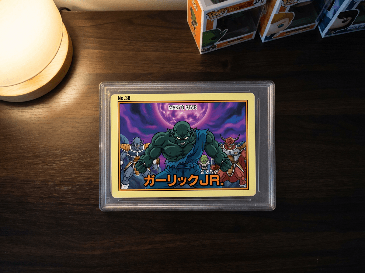 Rare 1991 Bandai Carddass card of Garlic Jr. and the Spice Boys in a plastic sleeve on a dark wooden collector